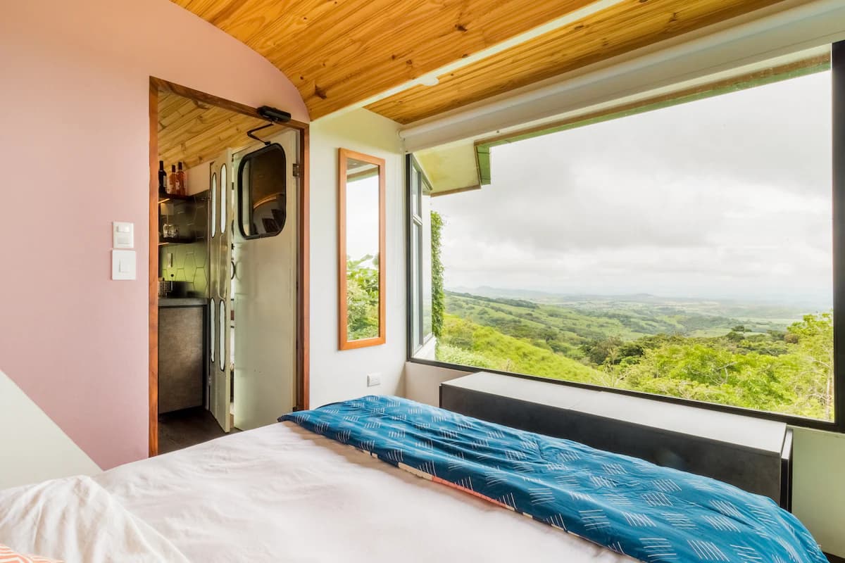 Bed beside a wide window over the valley